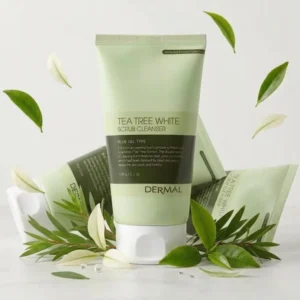 Vaaleanvihreä DERMAL Tea Tree White Scrub Cleanser 150 g -puhdistusvaahtotuubi pystyssä etualalla vaalealla pinnalla. Tuotteen takana kaksi tuubia makaa kyljellään, ja sen juurella on teepuun oksia. Tuotteen ympärillä leijuu vihreitä ja vaaleita lehtiä sekä pieniä vesipisaroita.