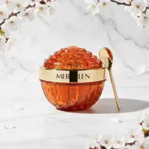 Oranssi, jalokiveä muistuttava Mercilen Ganoderma & Collagen -kasvovoidepurkki ja viininpunainen pakkaus.