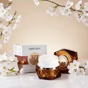 Meripihkan värinen, jalokivimäinen Mercilen-kasvovoidetölkki ja sen valkoinen, kohokuvioitu tuotepakkaus.