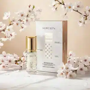 Kirkaslasinen Mercilen-hyaluronihapposeerumipullo kultaisella korkilla ja tyylikäs valko-kultainen tuotepakkaus.
