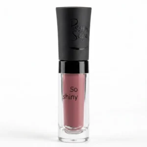 Peggy Sage So Shiny Cinnamon huulikiilto kirkkaassa hylsyssä, jossa näkyy pehmeän kanelinen, lämmin vanhan roosan sävy ja mattapintainen musta korkki.