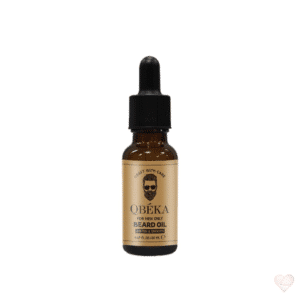 Ruskea lasinen pipettipullo, jonka kultaisessa etiketissä lukee QBÉKA Beard Oil ja on parrakkaan miehen kasvokuva.