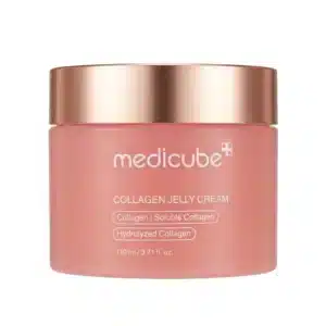 Pyöreä, lämpimän vaaleanpunainen Medicube Collagen Jelly Cream -kasvovoidepurkki ruusukultaisella metallikannella suoraan edestä kuvattuna puhtaalla valkoisella taustalla.