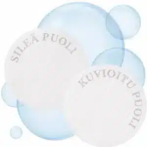 Kaksi pyöreää valkoista Medicube Zero Pore Pad -kuorintalappua vierekkäin; vasemmanpuoleisessa lapussa lukee kaarella teksti "SILEÄ PUOLI" ja oikeanpuoleisessa kohokuvioidussa lapussa teksti "KUVIOITU PUOLI" leijuvien vaaleansinisten vesikuplien ympäröimänä valkoisella taustalla.