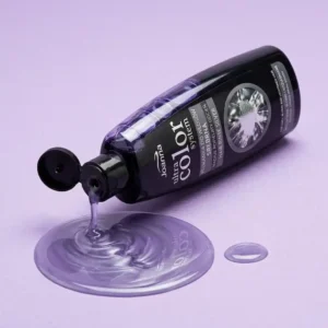 Joanna Ultra Color Silver -hopeahiusvesipullo kallellaan, josta valuu violettia nestettä siistiksi lammikoksi pehmeälle vaaleanvioletille taustalle.