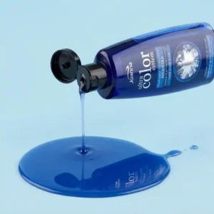 Sininen Joanna Ultra Color Blue -hiushuuhtelupullo kallellaan, josta valuu kirkasta sinistä nestettä siistiksi lammikoksi pehmeälle vaaleansiniselle taustalle.