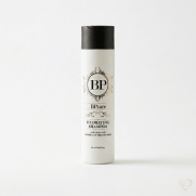 Valkoinen BPcare Hydrating Shampoo -pullo, jossa on musta korkki ja kultaisia koriste-elementtejä. Etiketissä on teksti "Hydrating Shampoo for long and chemically treated hair". Pullo on kuvattu vaaleaa, pelkistettyä taustaa vasten.
