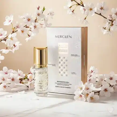 Kirkaslasinen Mercilen-hyaluronihapposeerumipullo kultaisella korkilla ja tyylikäs valko-kultainen tuotepakkaus.