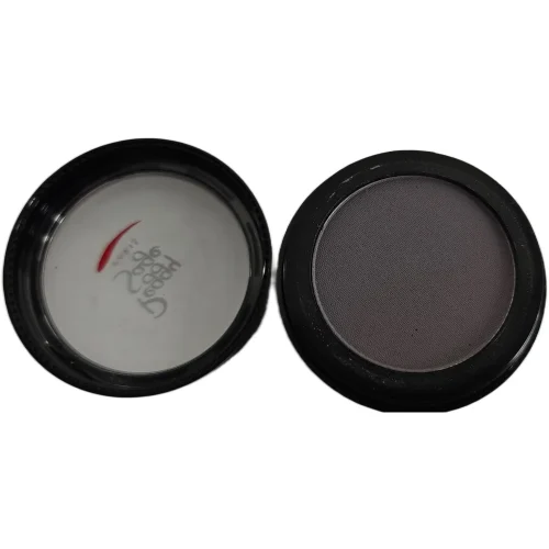 Avattu pyöreä Peggy Sage -luomivärinappi sävyssä Cherished Grey. Oikealla tummanharmaa luomiväri mustassa rasiassa ja vasemmalla puolella läpinäkyvä kansi, jossa näkyy Peggy Sage -logo ja punainen yksityiskohta valkoista taustaa vasten.