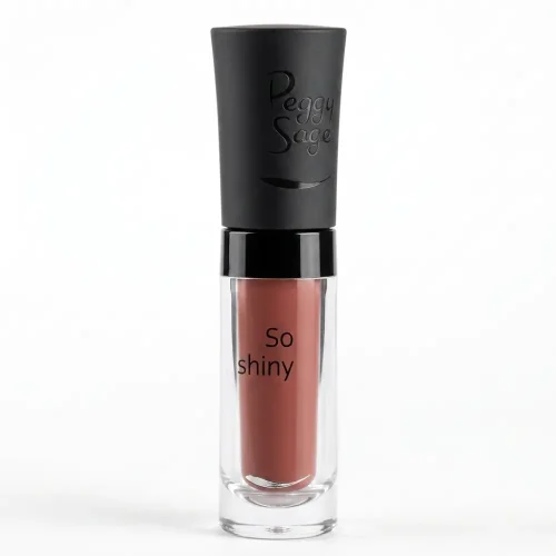 Peggy Sage So Shiny Chic 005 huulikiilto läpinäkyvässä pakkauksessa, jossa näkyy lämmin nudenruskea sävy ja mattamusta korkki Peggy Sage -logolla.